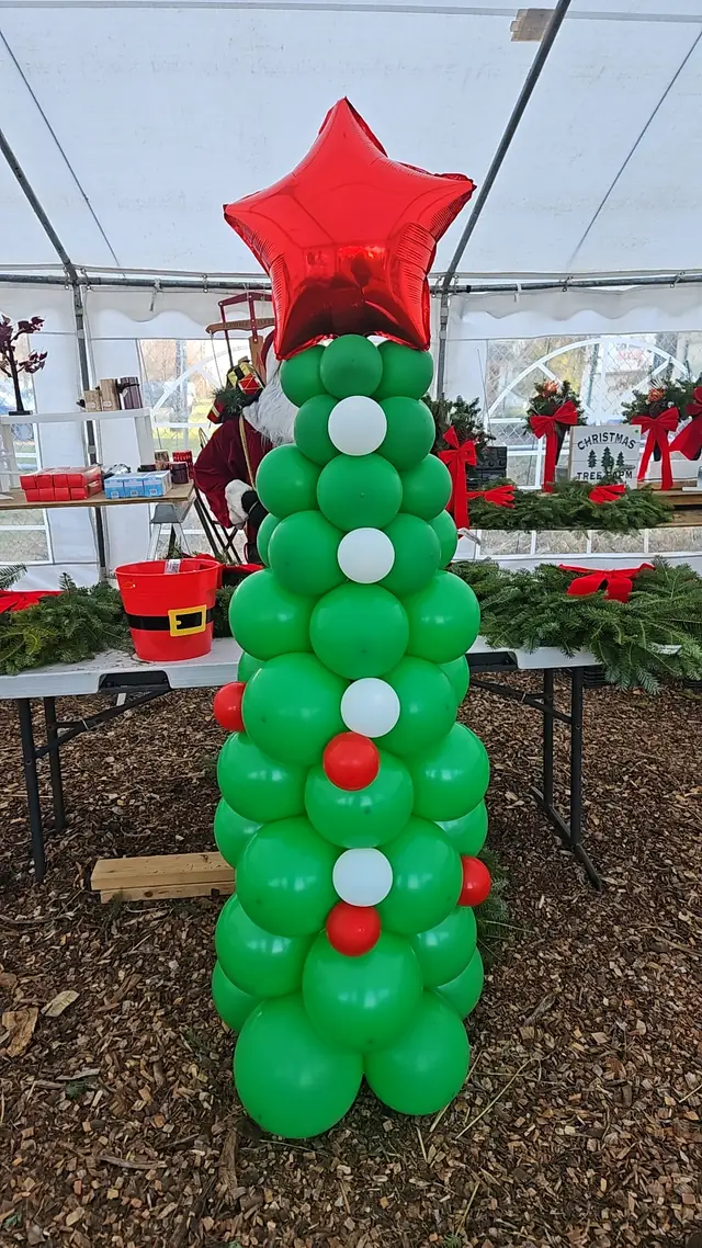 Green and red balloon Christmas tree column inside a tent